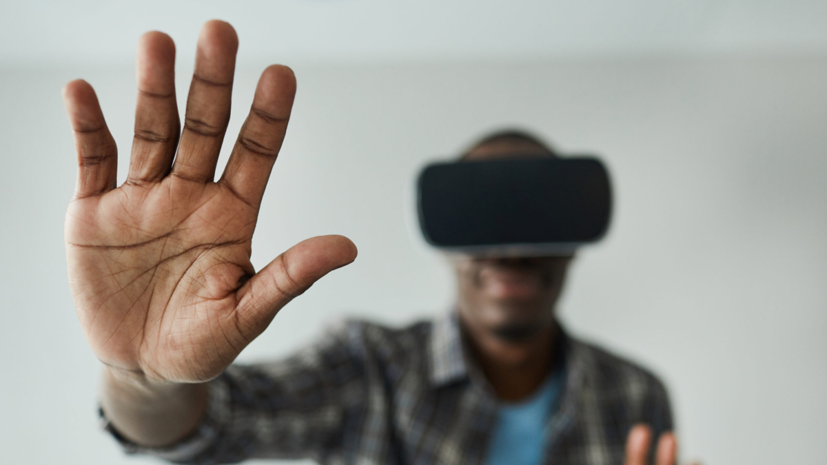 African man in glasses gesturing while playing in virtual reality game