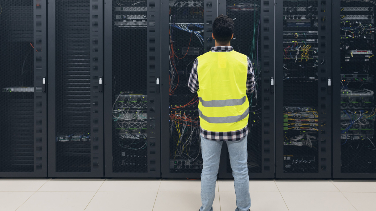 Male informatic engineer working inside server room database